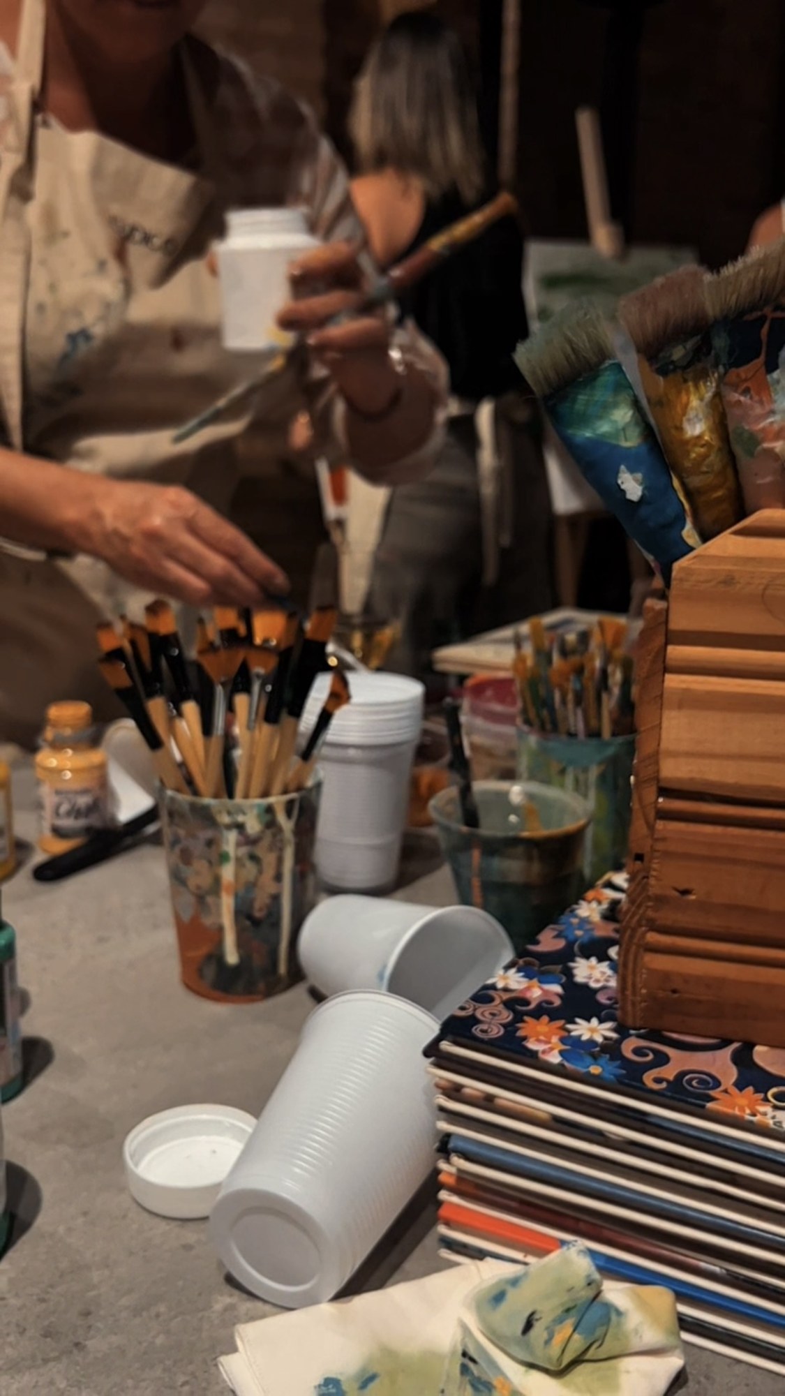 Mãos, pincéis e tintas em um momento de experimentação