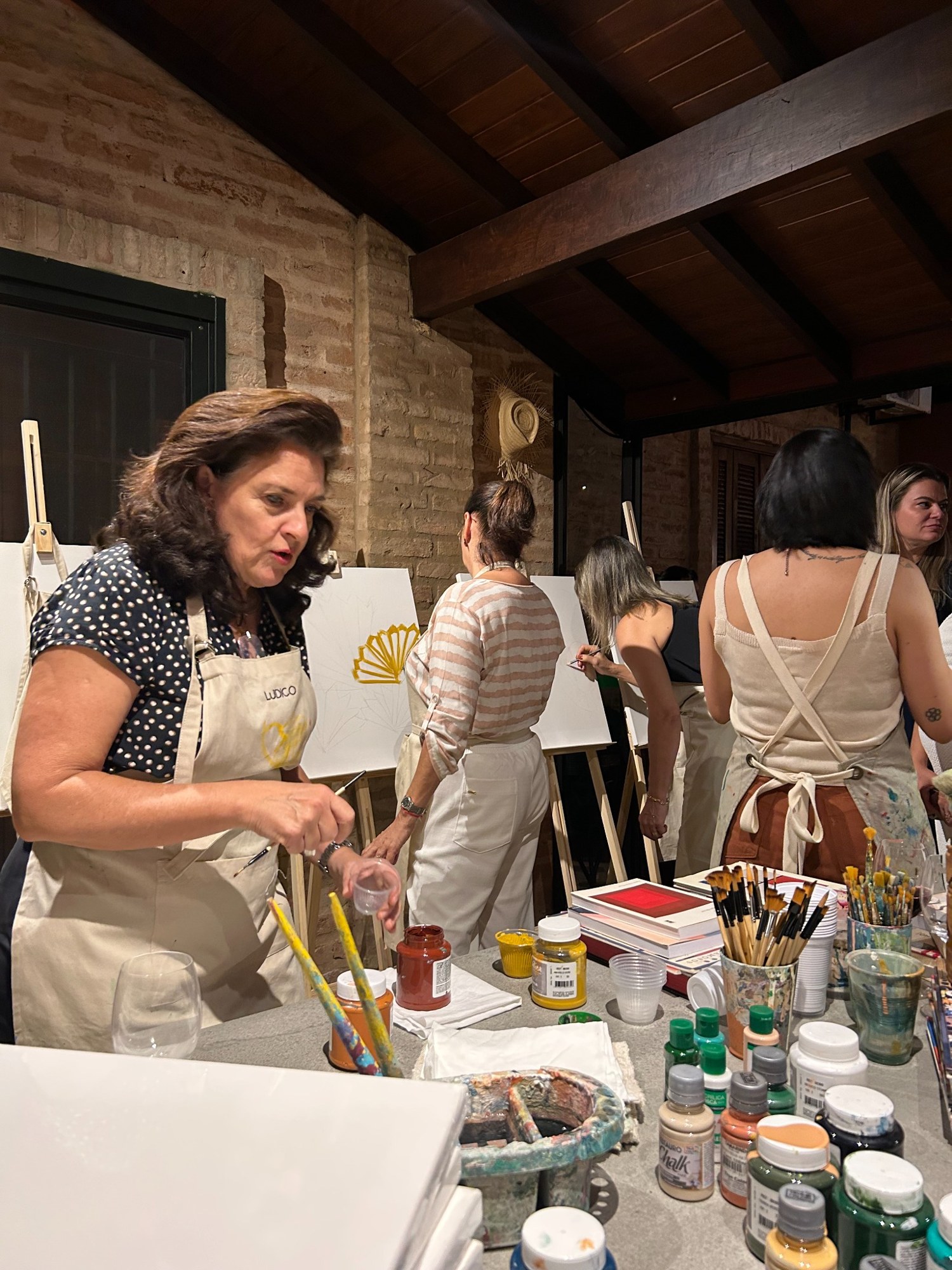 Participantes escolhendo e experimentando materiais de pintura
