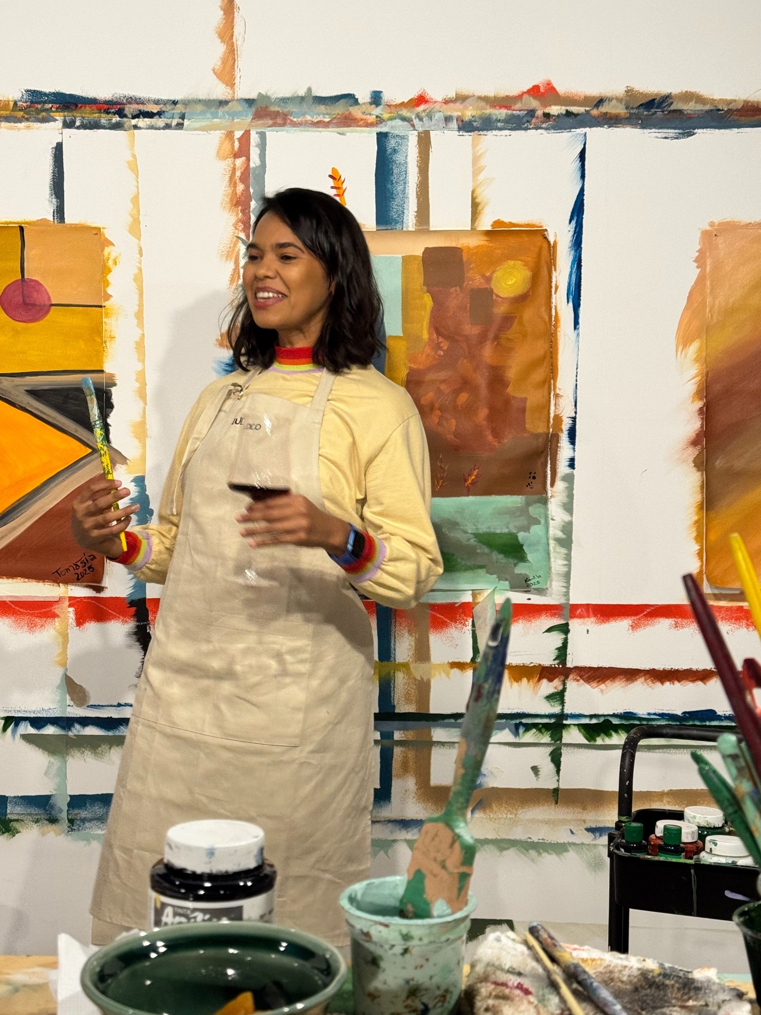 Participante junto à sua pintura e aos materiais da vivência