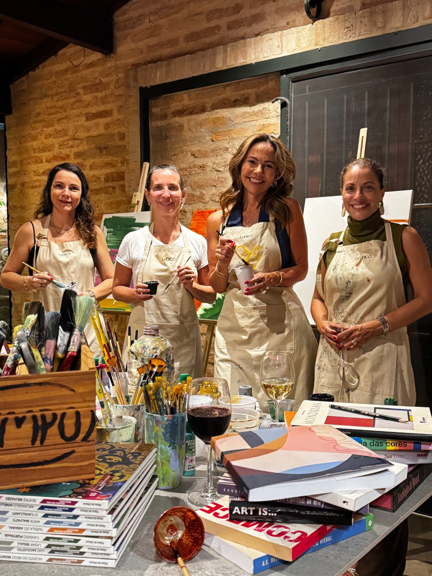 Participantes reunidas entre pinturas e materiais